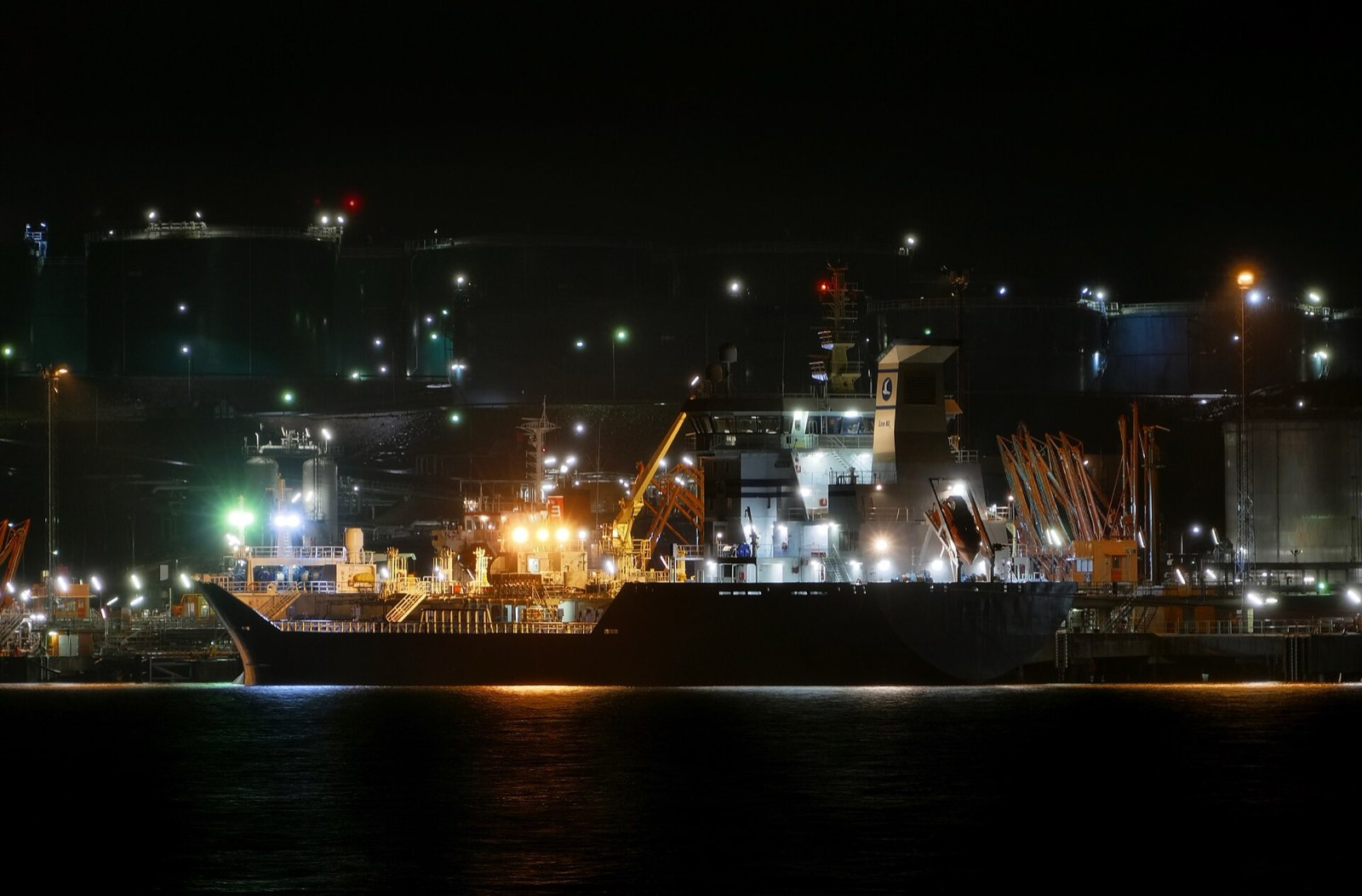 Product tanker loading at an illuminated sea terminal at night